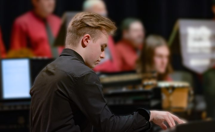 Weet. playing piano on stage